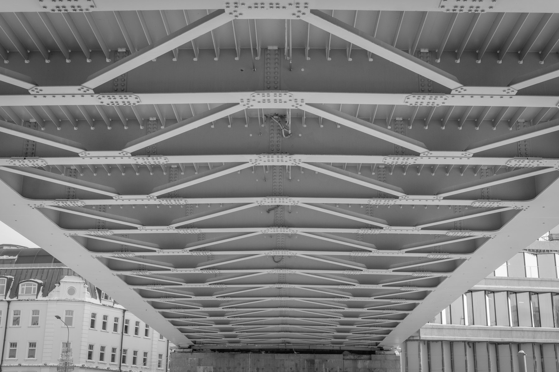 The geometric steel underside of a bridge, evoking structural change in progress.