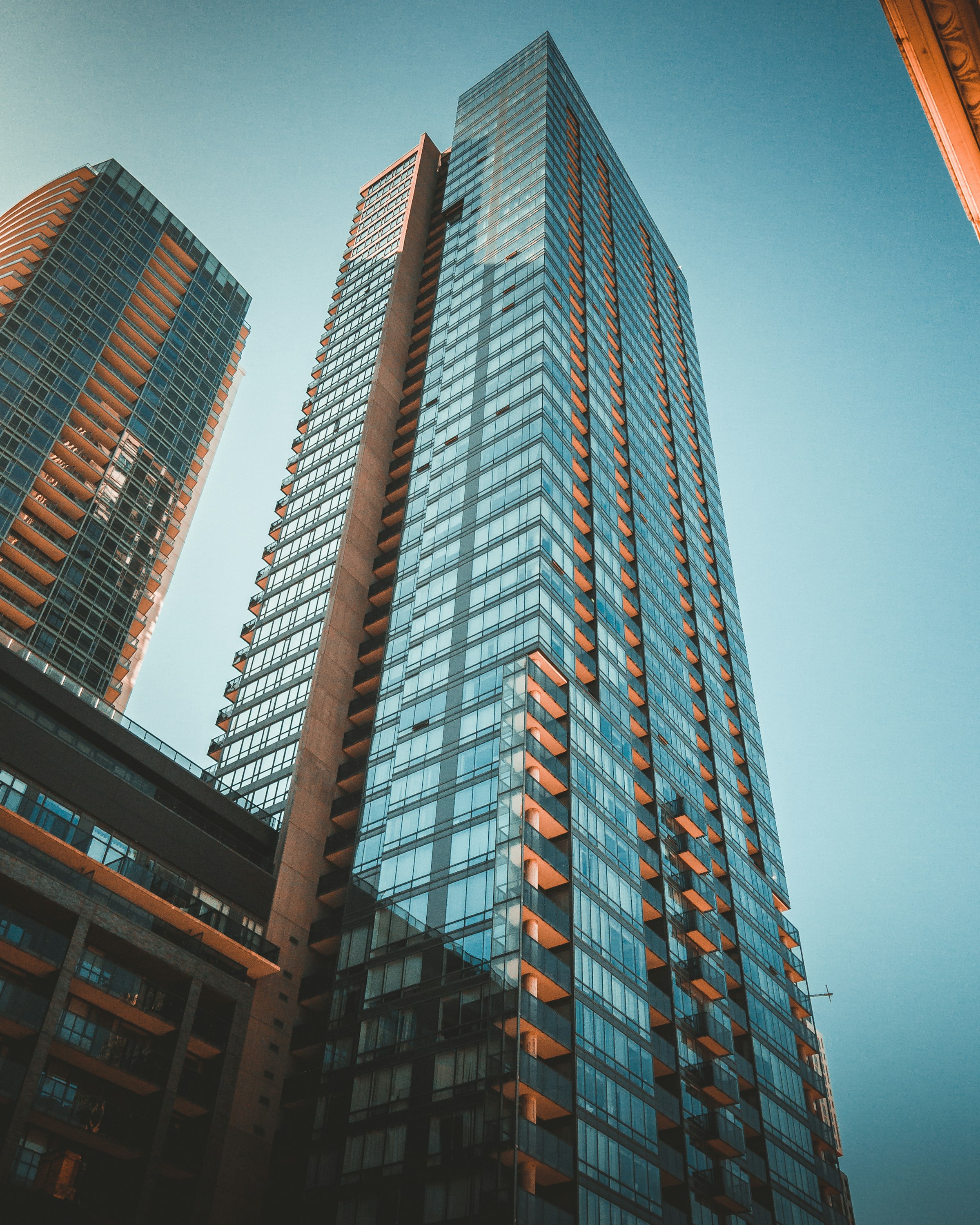 A glass tower building against a clear sky.